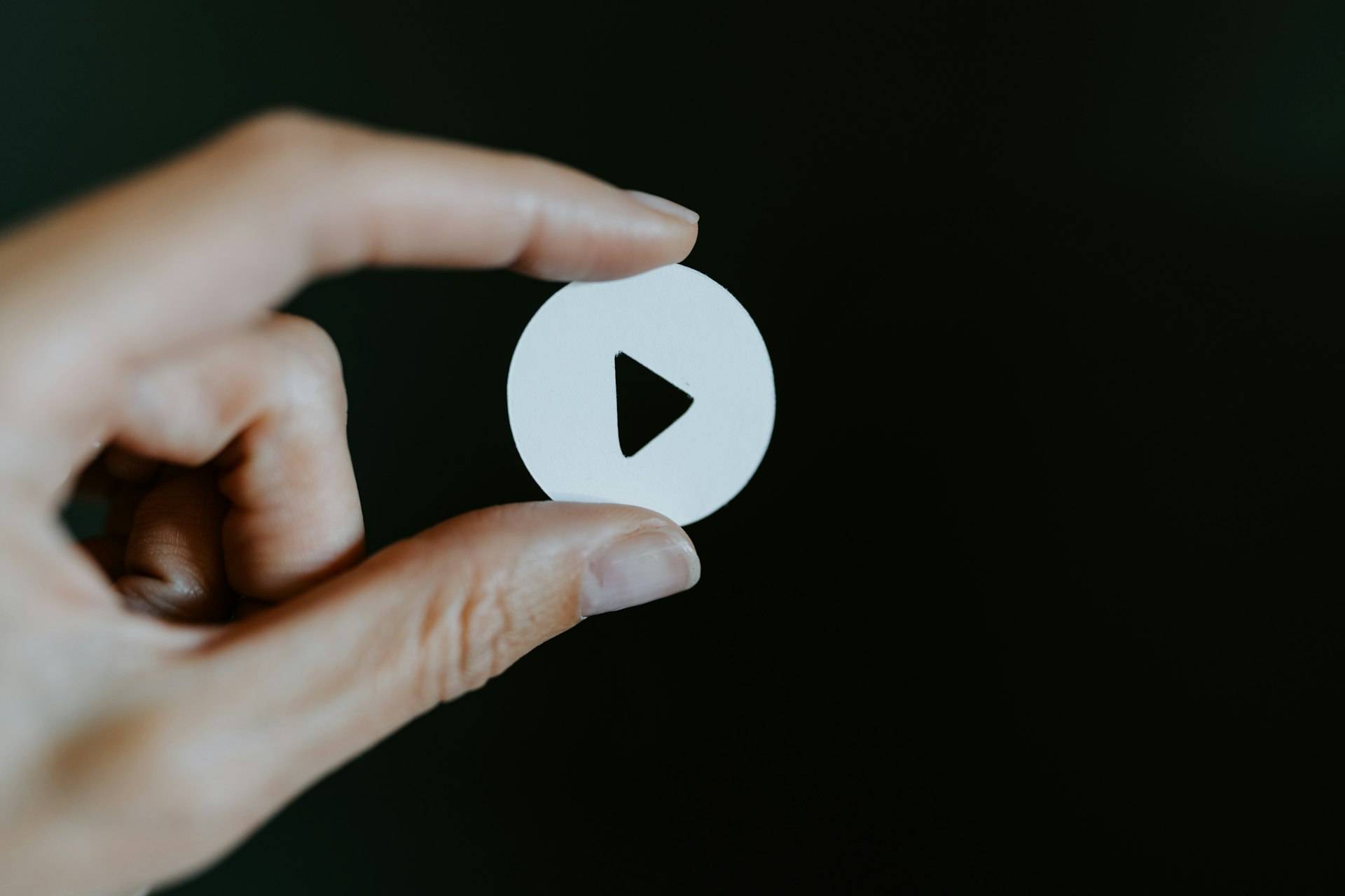 a hand per cut out of a video play button